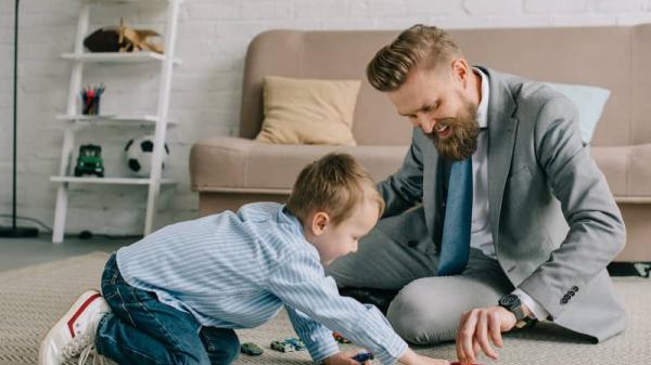 un père rentrant du travail joue avec son fils